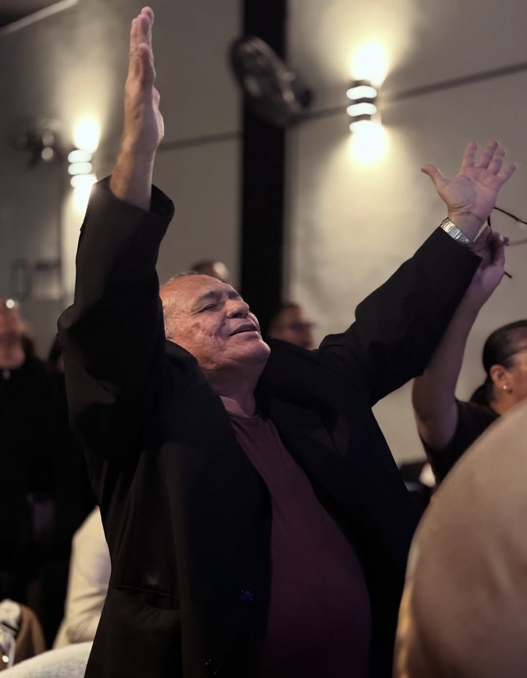 Membro da igreja em adoração com as mãos erguidas